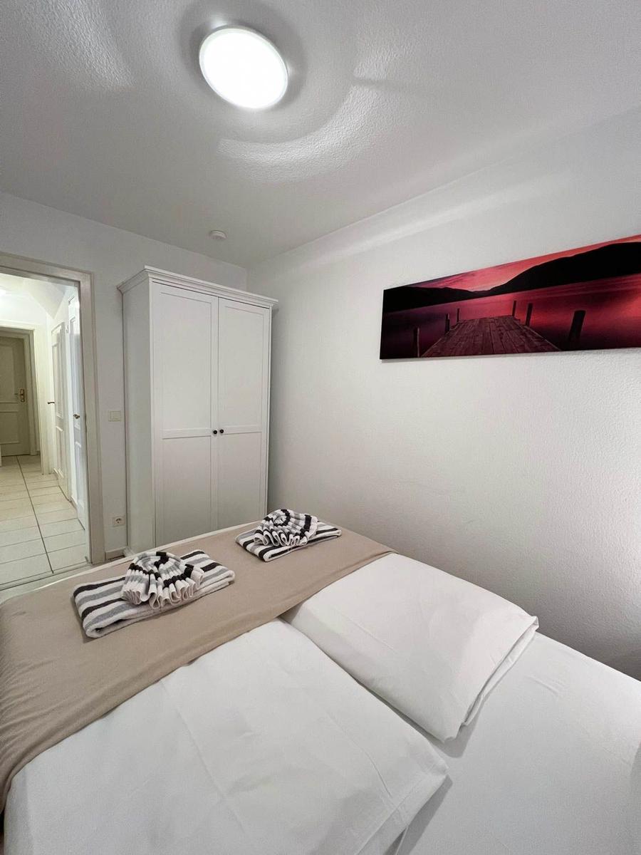 Schlafzimmer mit Bett, Kleiderschrank und Wandbild
