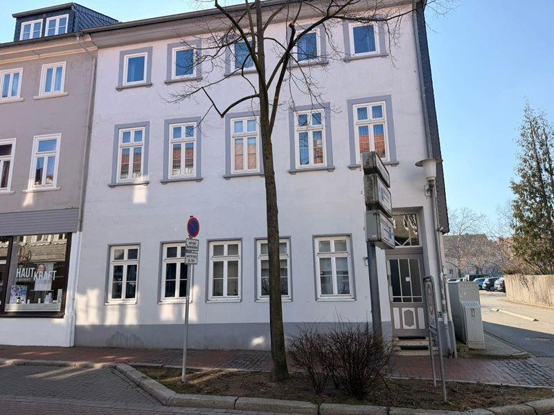Fassade eines mehrstöckigen Gebäudes mit Fenstern und Eingangstür.