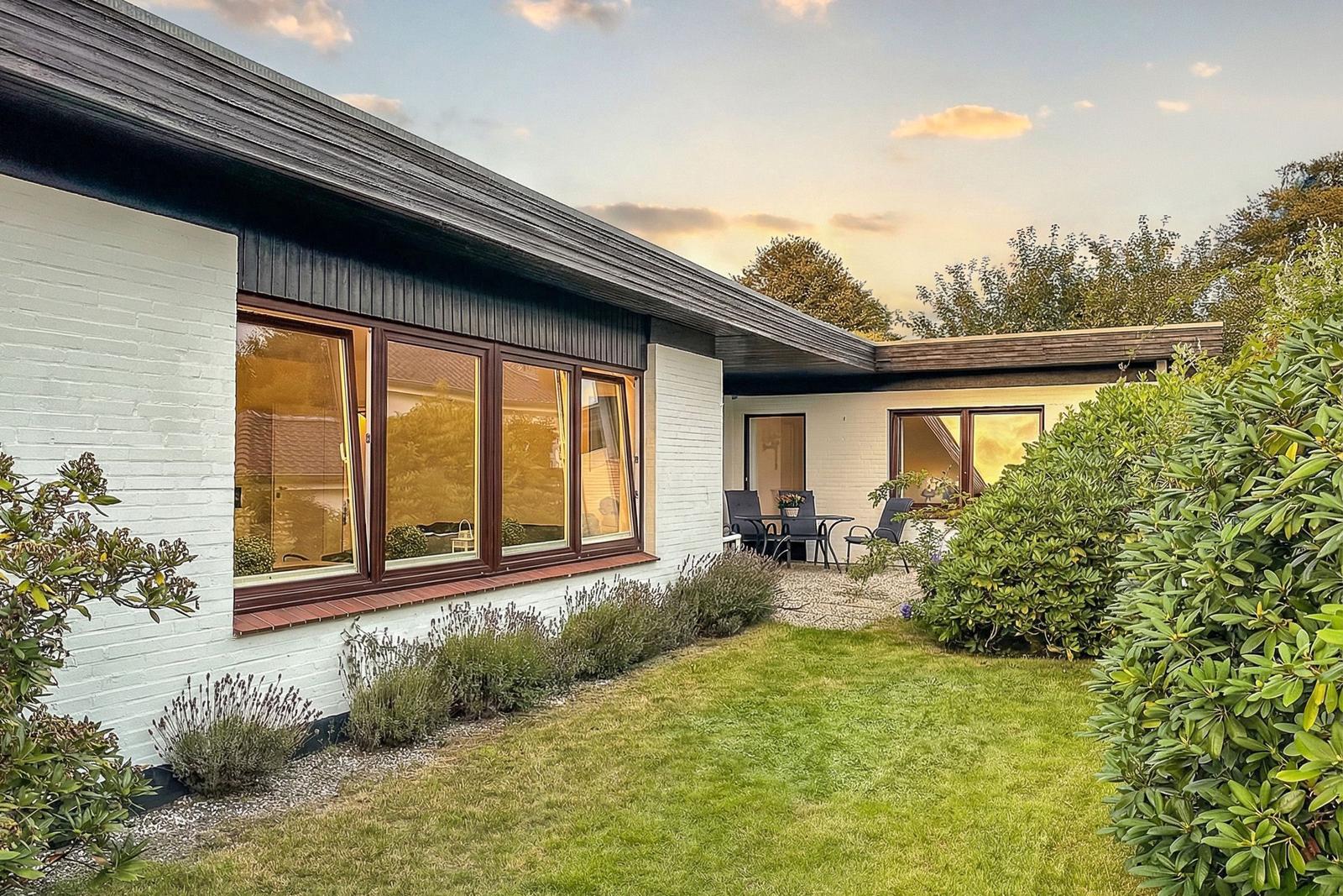 House with garden and terrace. Windows show inside.