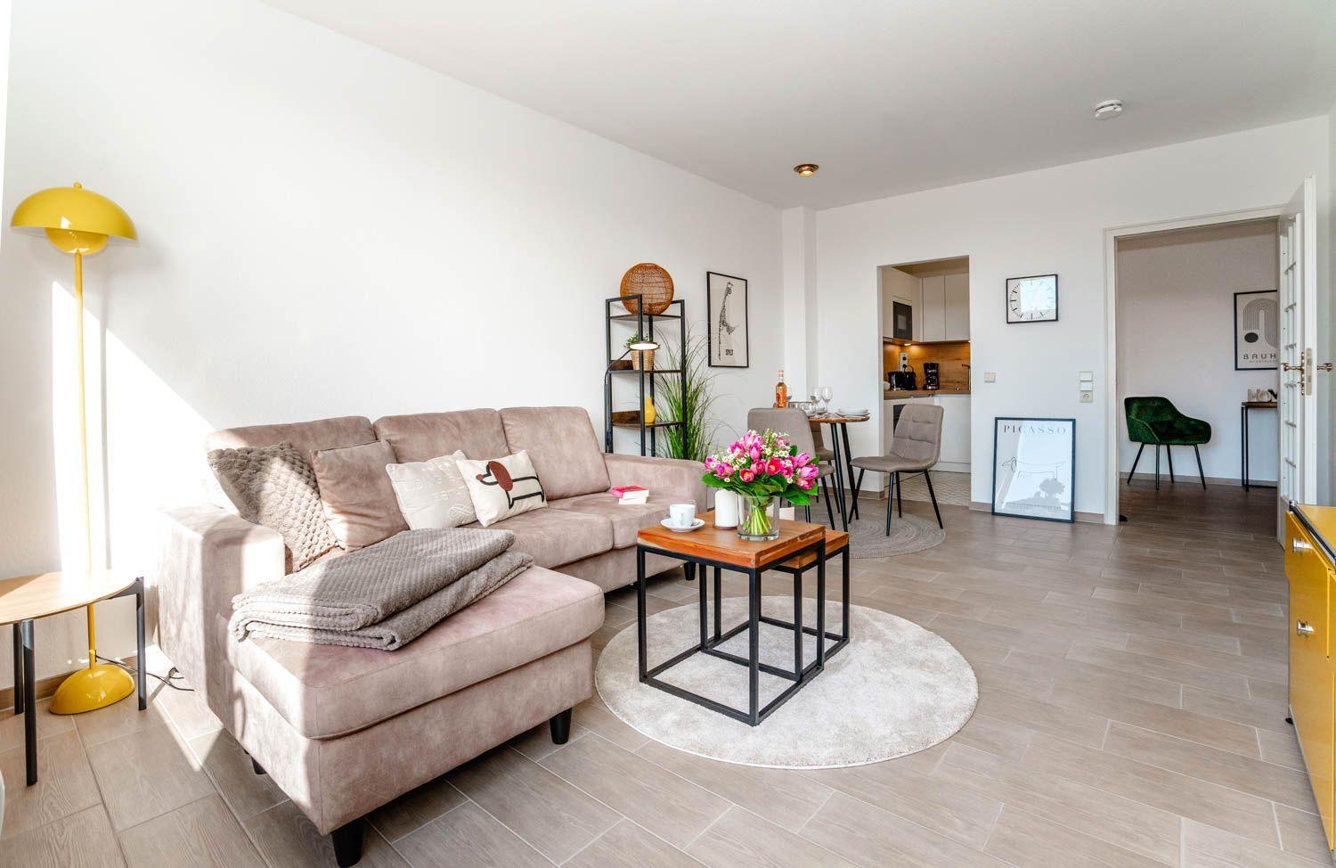 Wohnzimmer mit Sofa, Couchtisch und Blick in die Küche und Schlafzimmer.