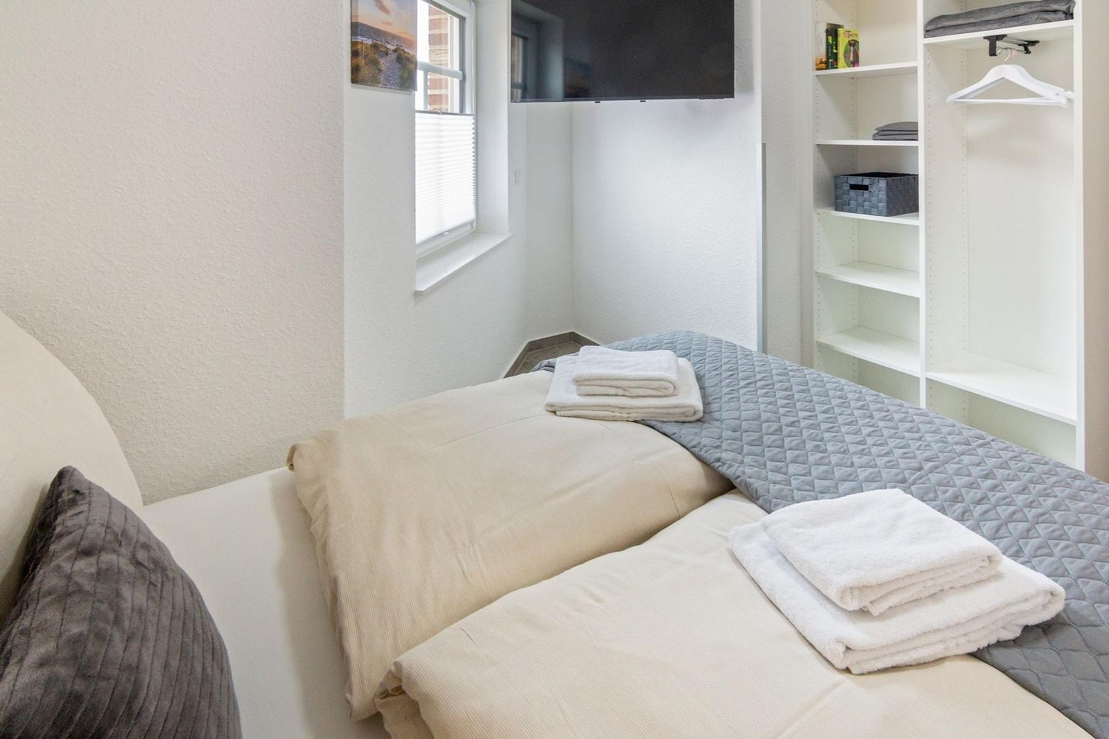 Ein Schlafzimmer mit Bett, TV und Kleiderschrank.
