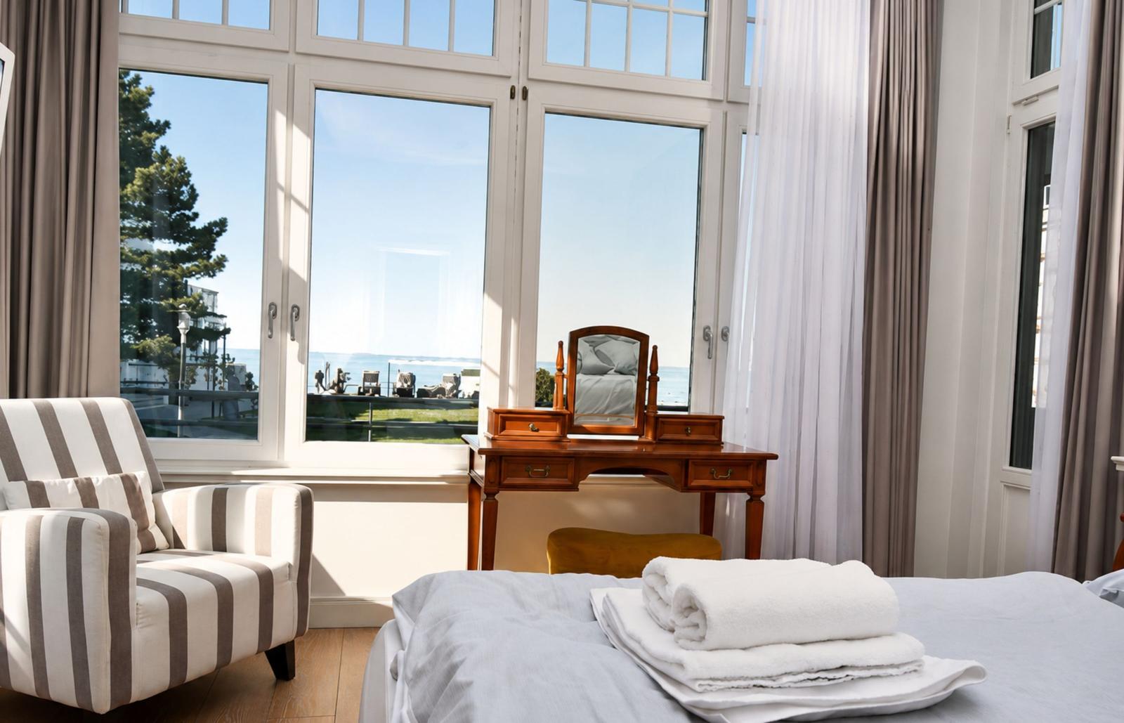 Zimmer mit Blick aufs Meer, Bett, Stuhl und Schminktisch