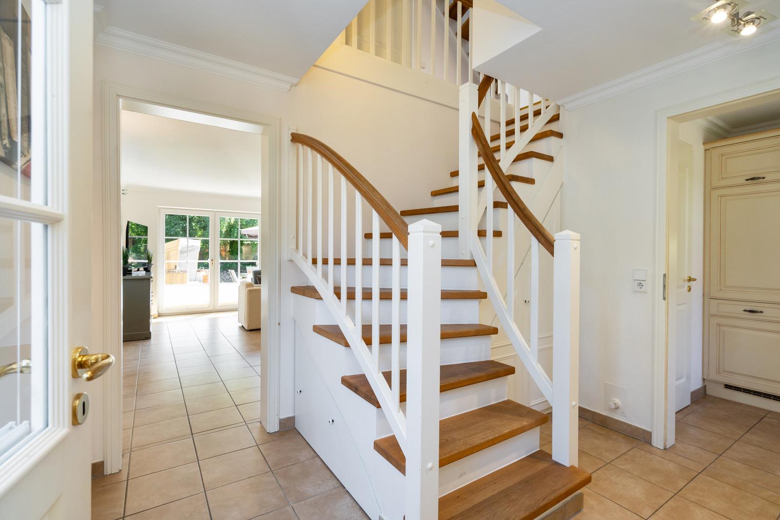 Haus mit Treppe und Blick in Wohnbereich und Küche