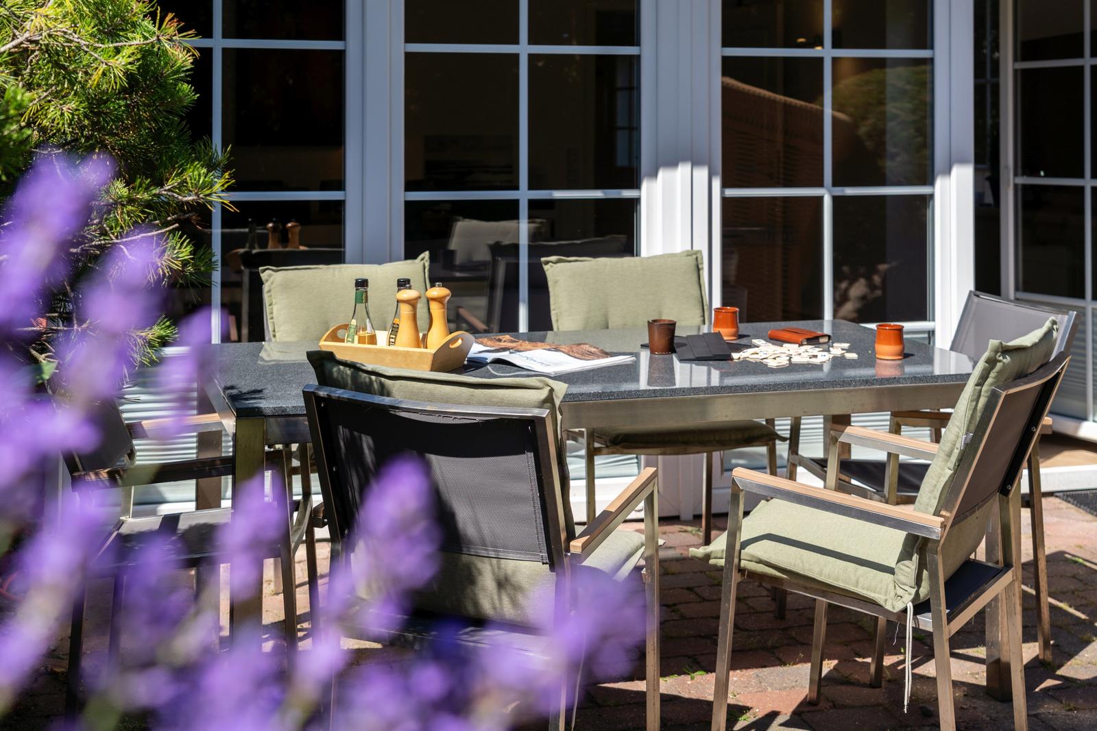 Terrassentisch mit Stühlen und Tischdekoration im Freien.
