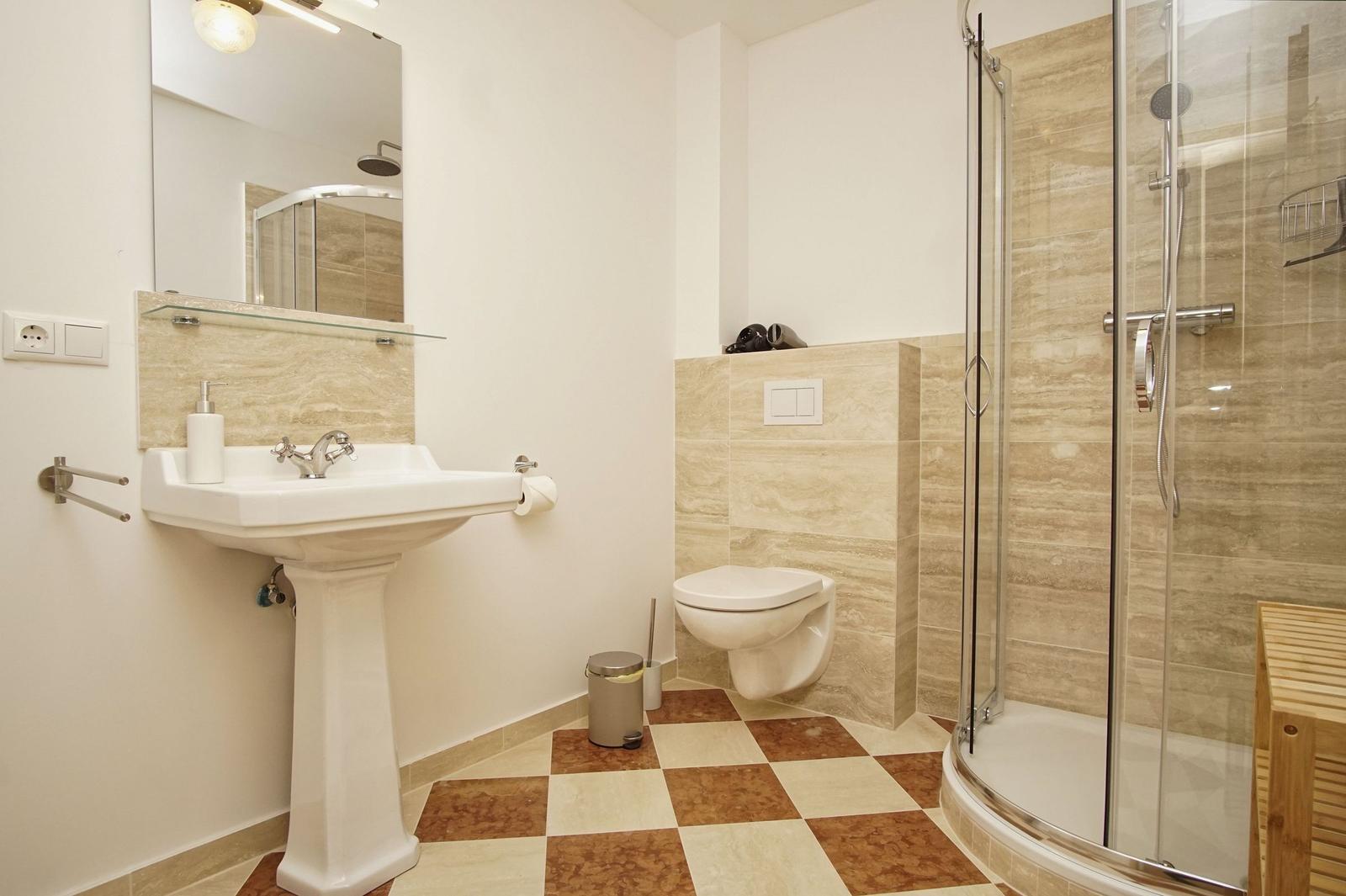 Badezimmer mit Dusche, Waschbecken und Toilette.