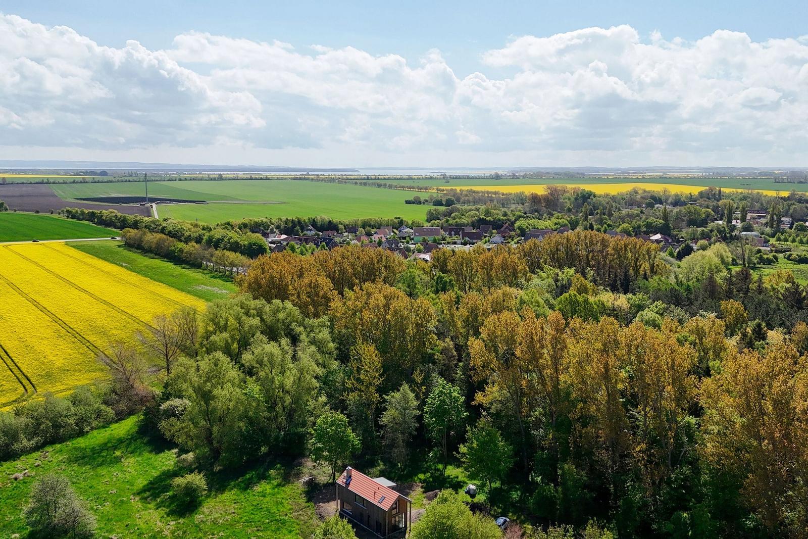 Haus im Wald mit Blick auf Felder und Dorf.