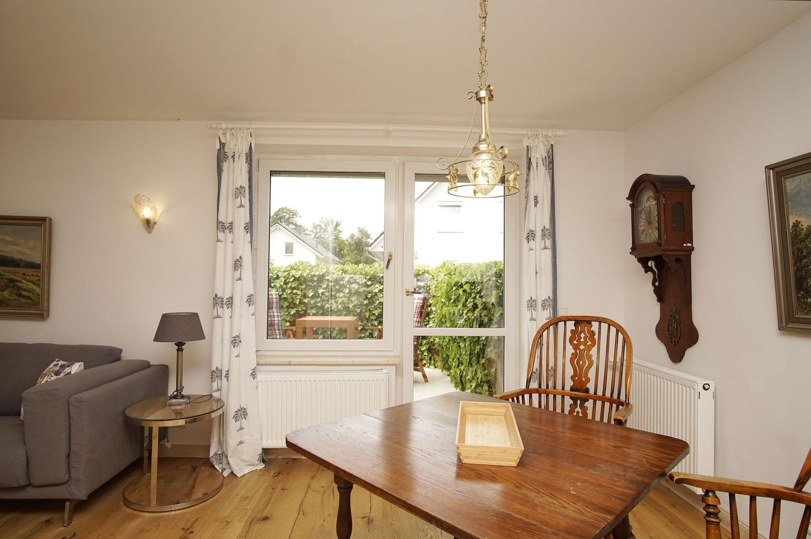 Ein Esszimmer mit Holztisch, Stühlen und Blick auf einen Garten.