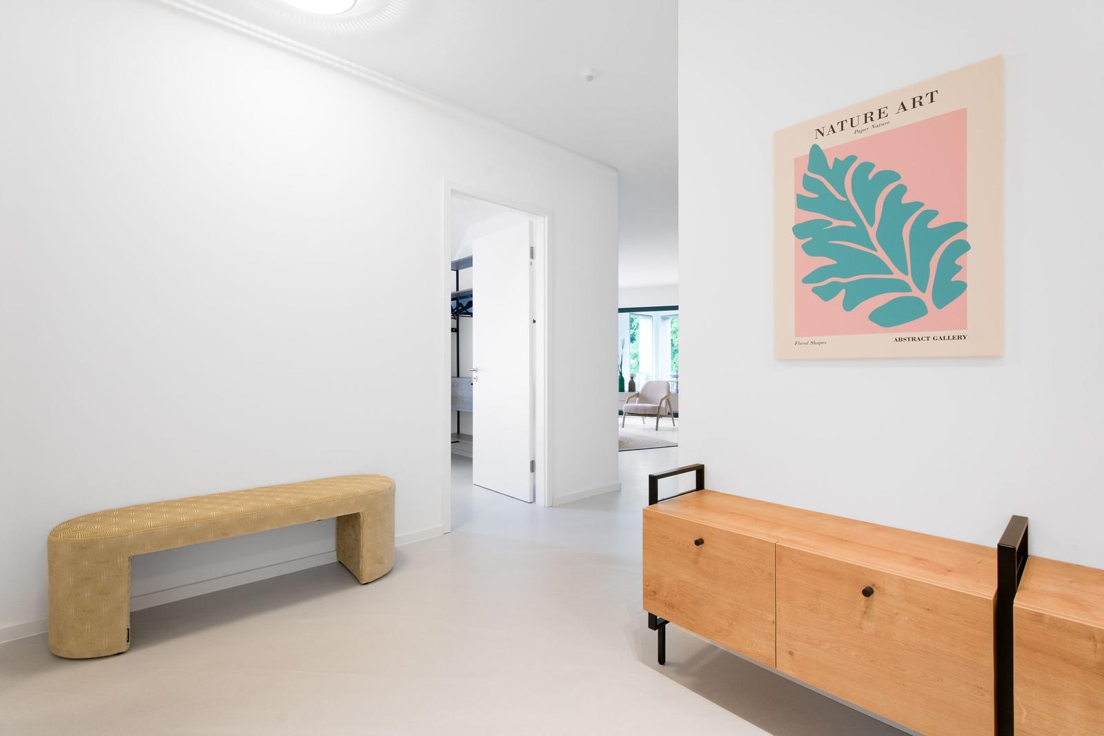 Flur mit Bank, Sideboard und Wandbild. Tür führt in Schlafzimmer.