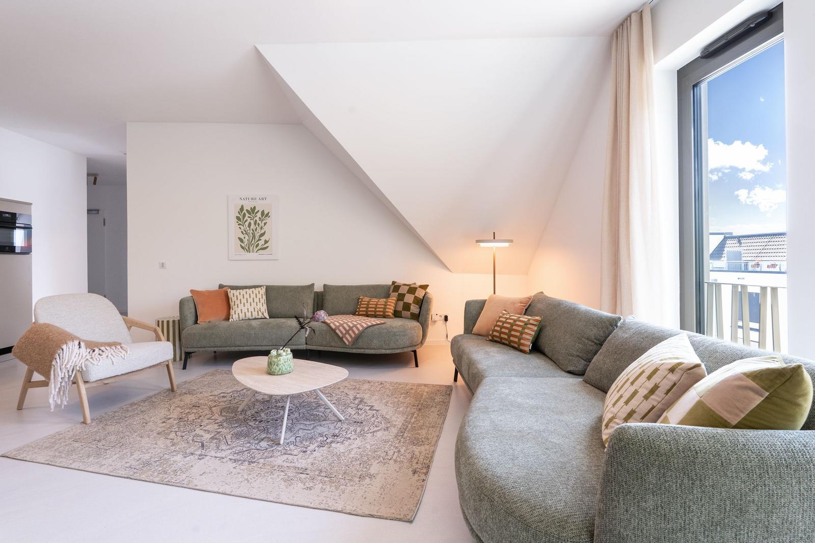 Wohnzimmer mit zwei Sofas, Tisch und Fenster zur Aussicht.