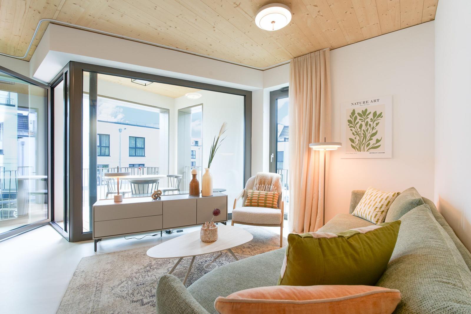 Wohnzimmer mit Sofa, Couchtisch und Glasfront zur Terrasse.