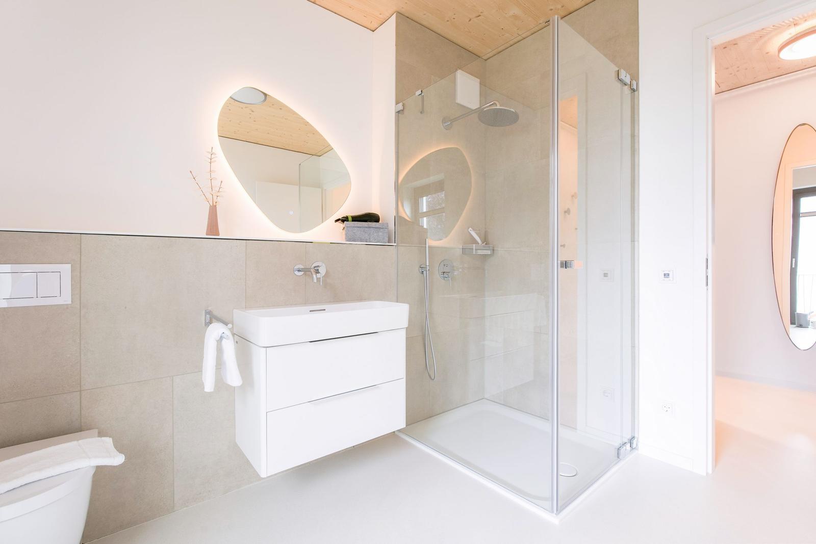 Moderne Badewanne mit Dusche, Waschbecken und Spiegel.