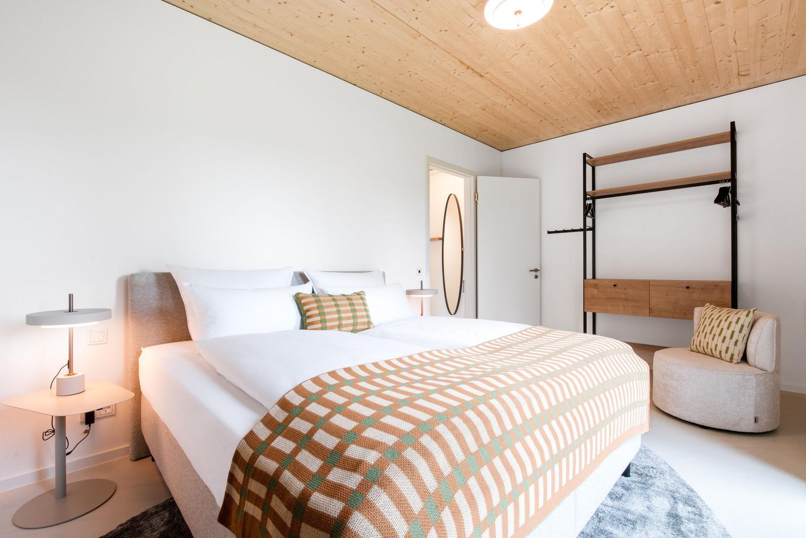 Schlafzimmer mit Doppelbett, Holzdecke und Kleiderständer