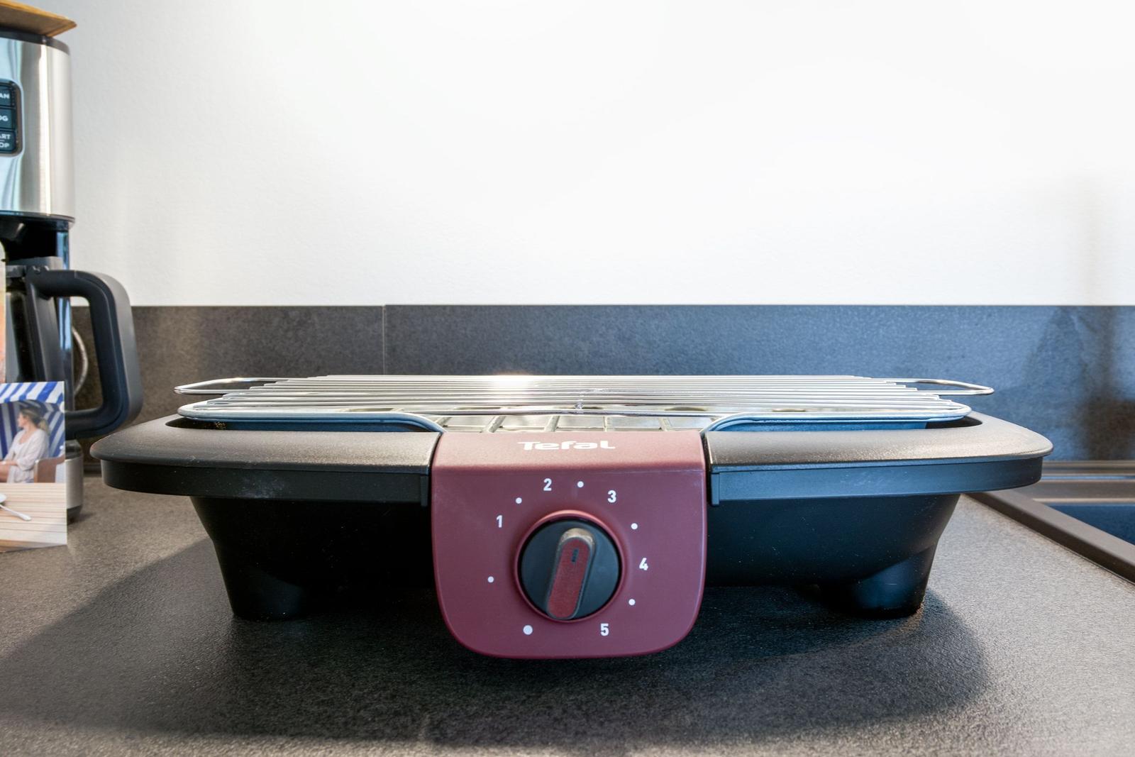 Tefal Elektrogrill auf Küchenarbeitsfläche mit Drehregler und Grillrost.