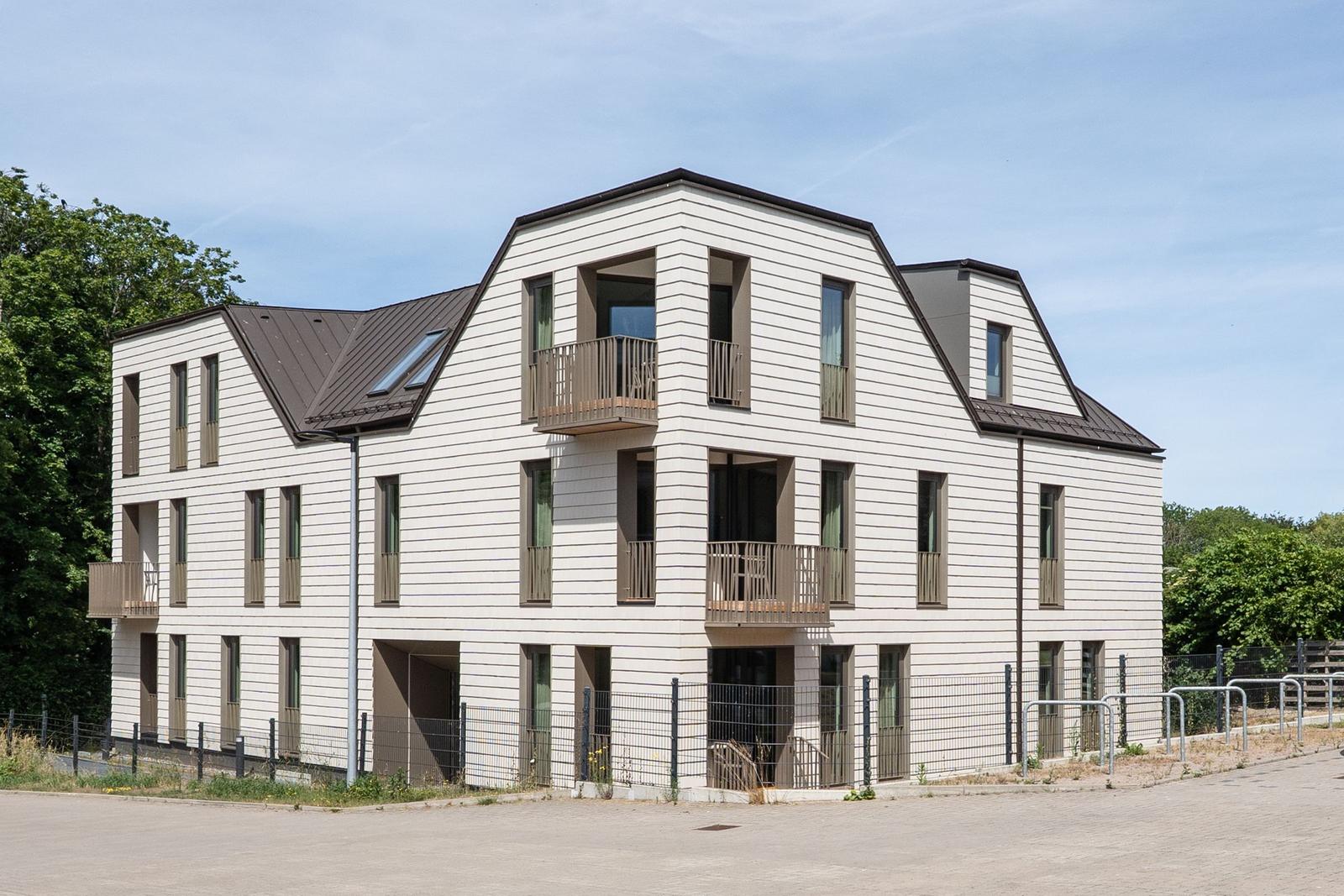 Moderne mehrstöckige Wohnung mit Balkonen und Fenstern.