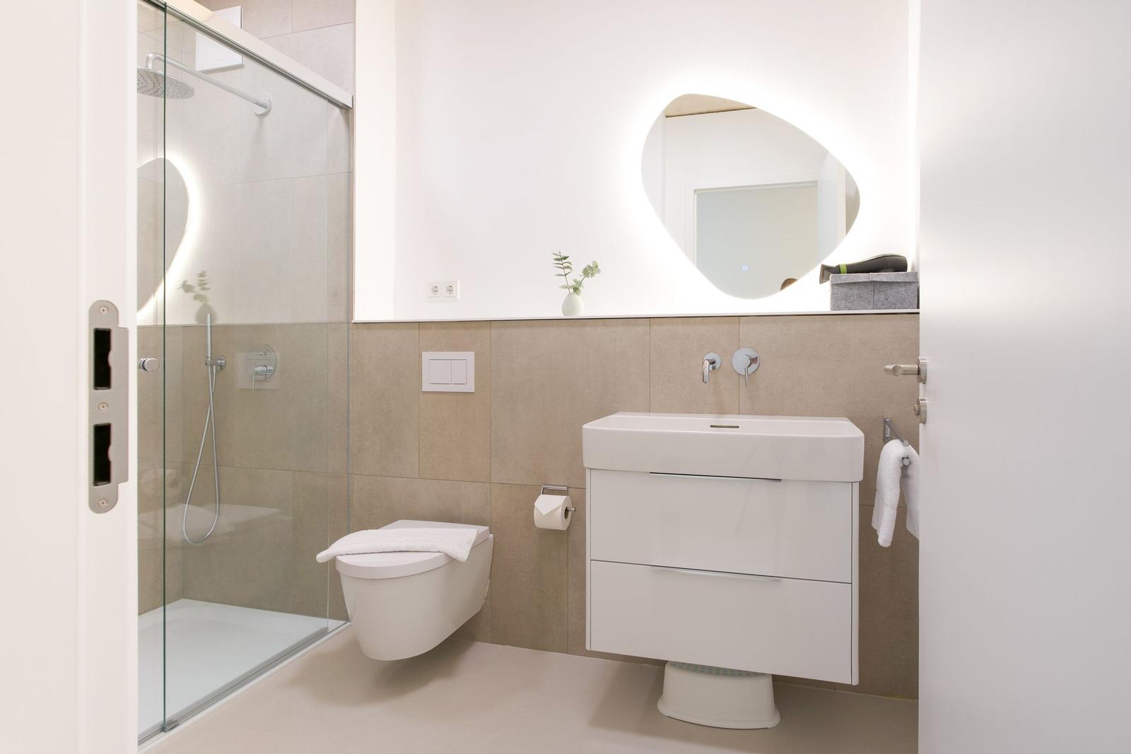 Moderne Badezimmer mit Dusche, Toilette und Waschbecken.