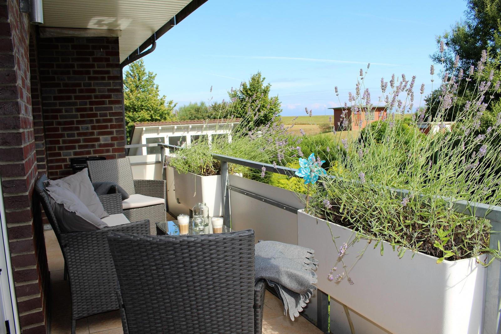 Terrasse mit Sitzgruppe, Pflanzen und Blick auf Landschaft.