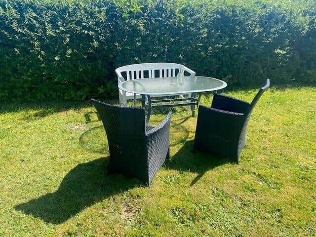 Outdoor area with round table and four chairs on grass