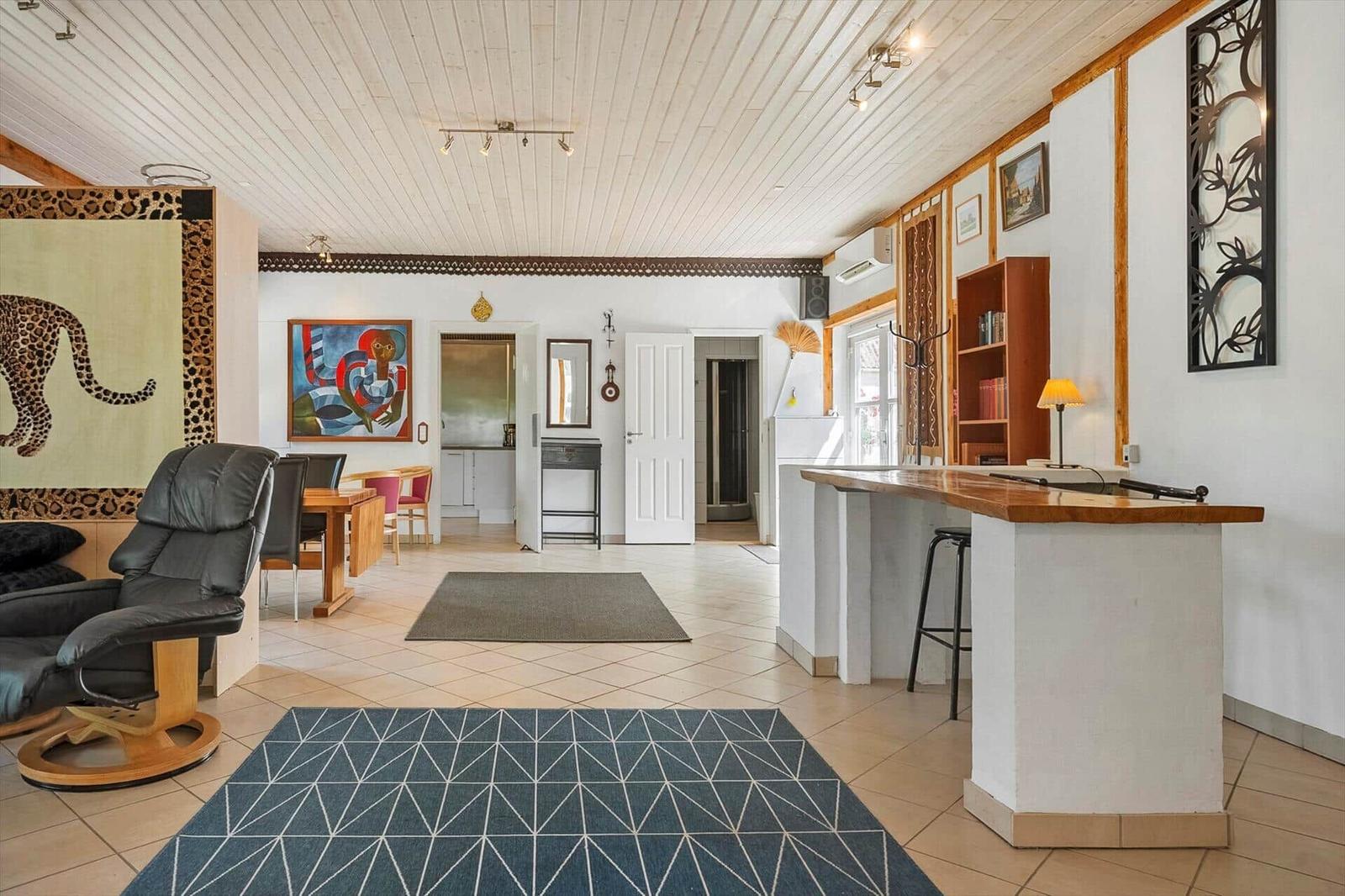Living area with dining space, bar, and artwork on the walls.