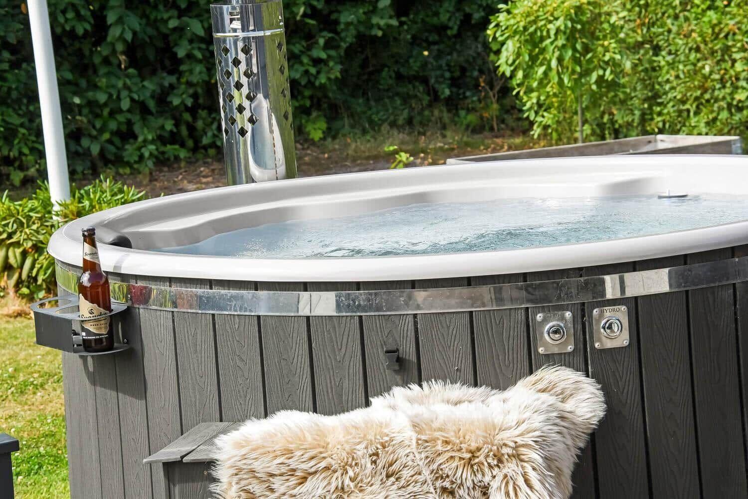 Ein Whirlpool mit Holzverkleidung und einer Bierflasche auf einem Halter.
