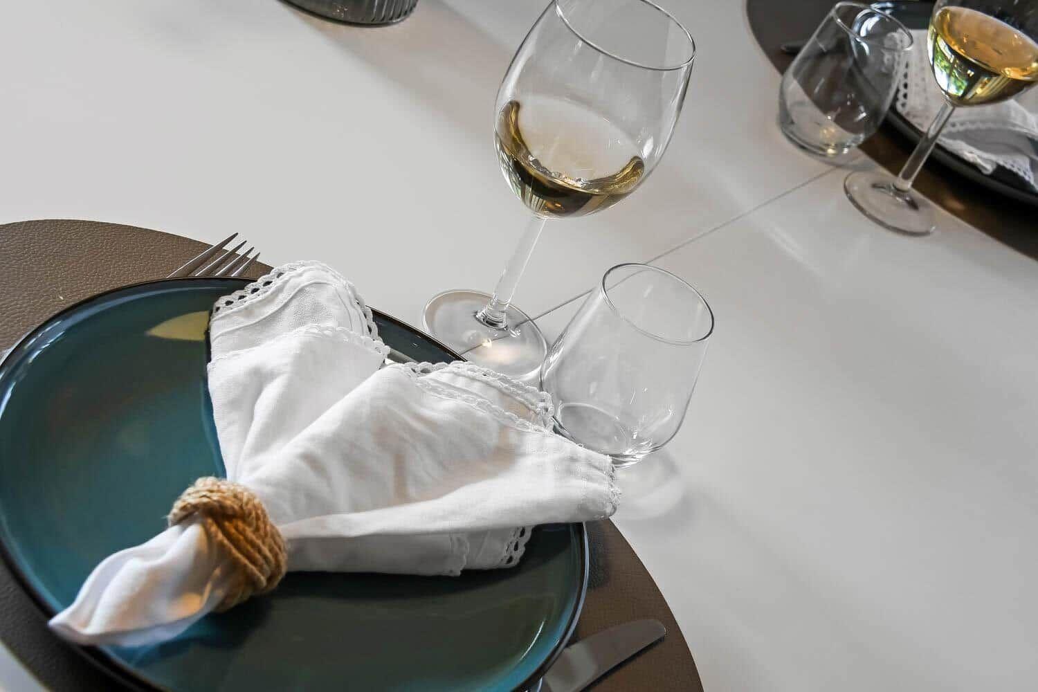 Tisch mit Teller, Serviette, Wein und Wasserglas