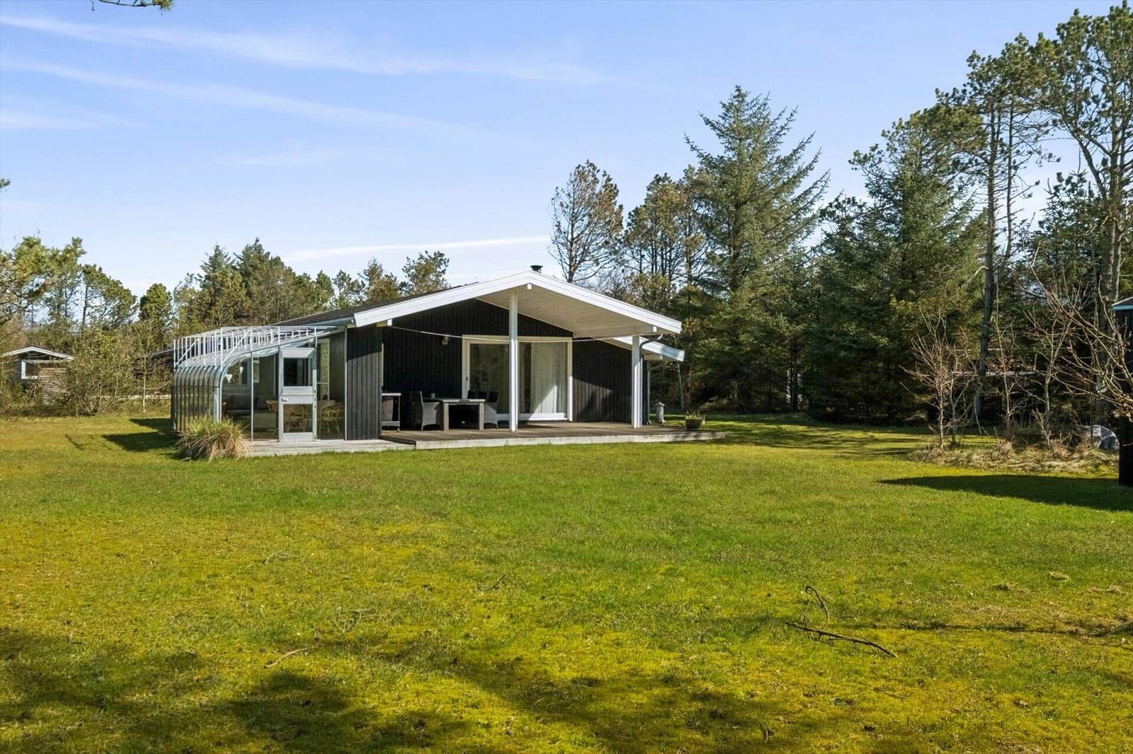 Modern cabin with terrace and lawn in the forest