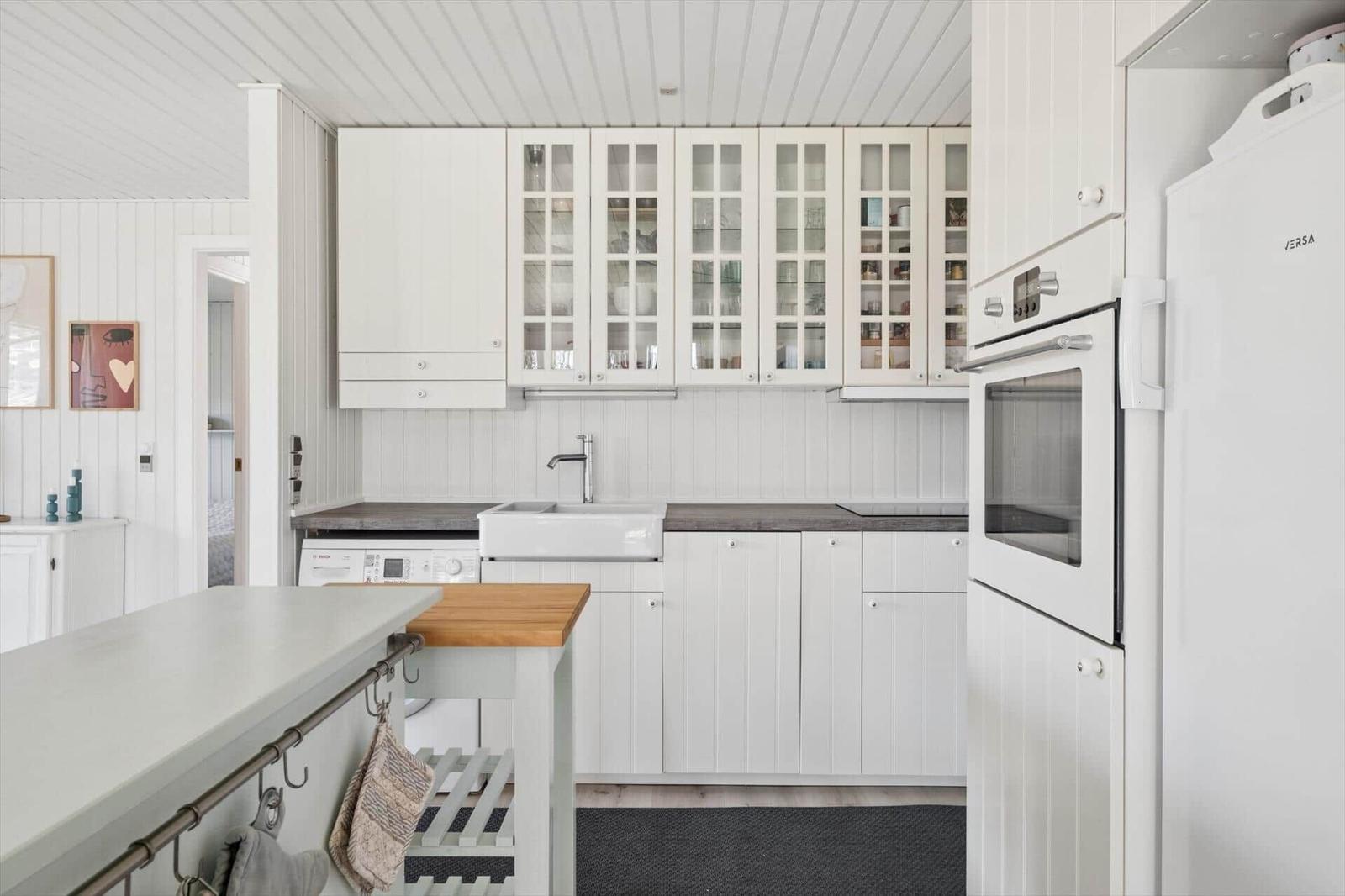 Kitchen with white cabinets, countertop, and sink. Includes dishwasher and refrigerator.