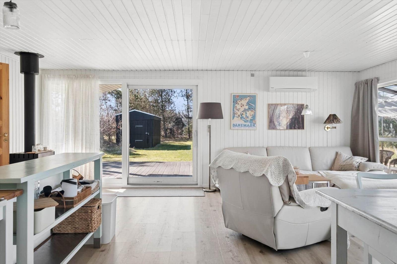 Living room with sofa, blanket, and view of the terrace