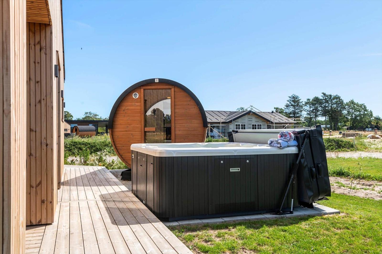 Hochwertige Whirlpoolanlage mit Holzsauna auf Terrasse im Freien.