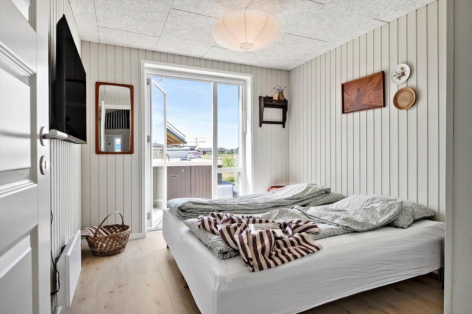 Bedroom with bed, window, and wall decor.