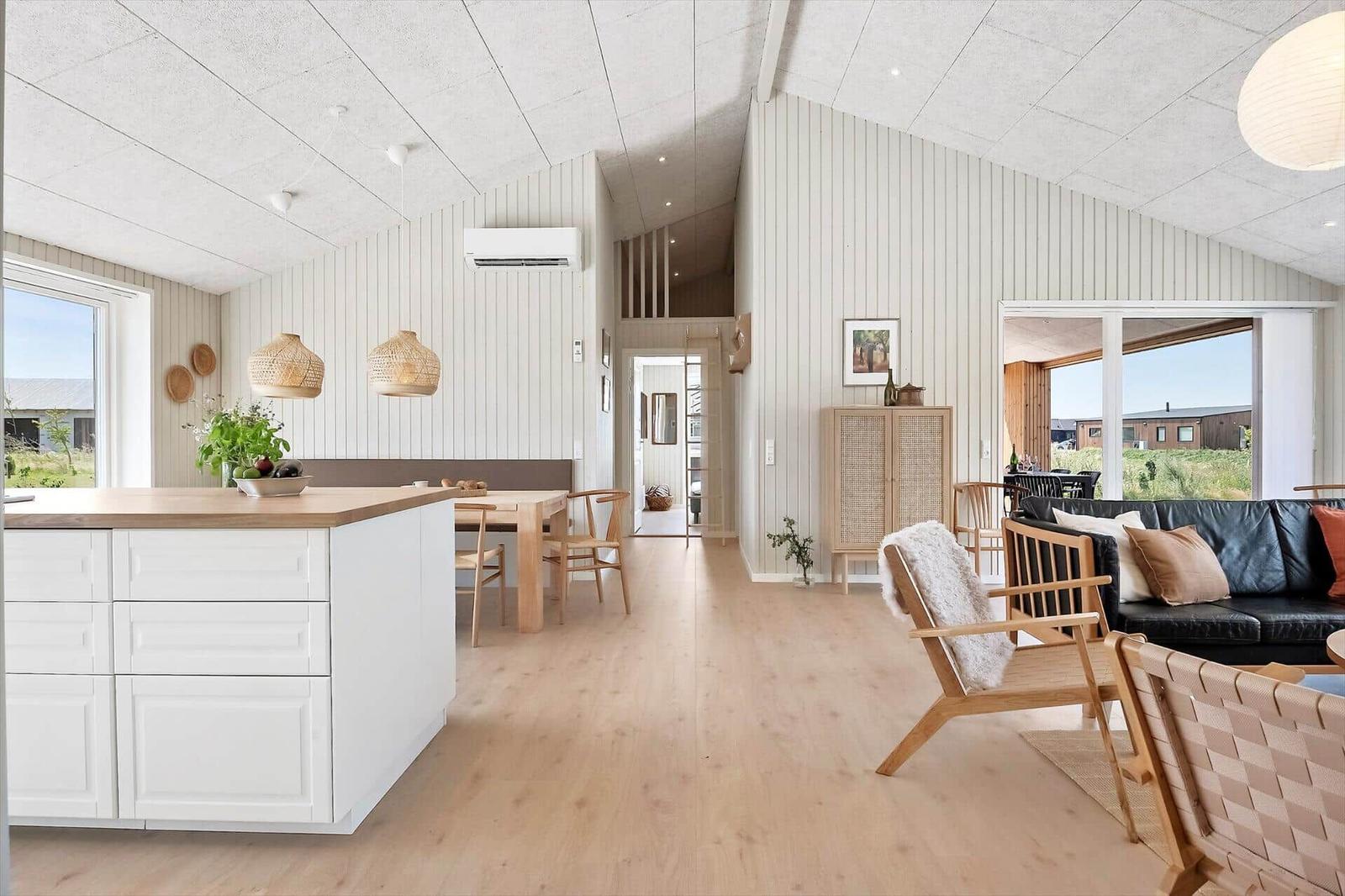 Living and dining area with wooden floor, white walls, and modern furniture.