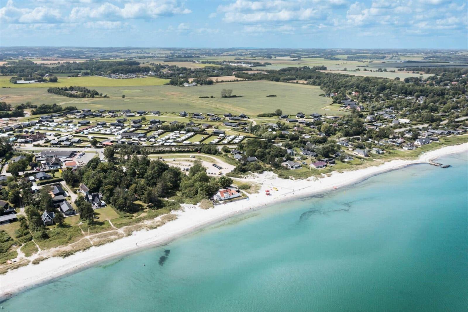 Aerial view of a beach with holiday homes and camping site