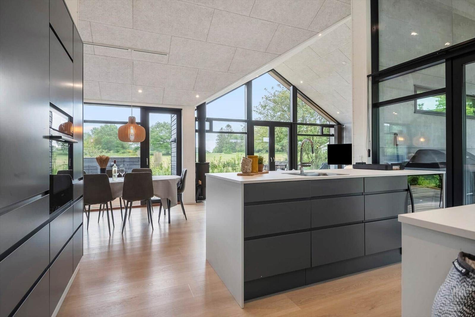 Moderne Küche mit Essbereich und großem Fensterblick auf Grünland.