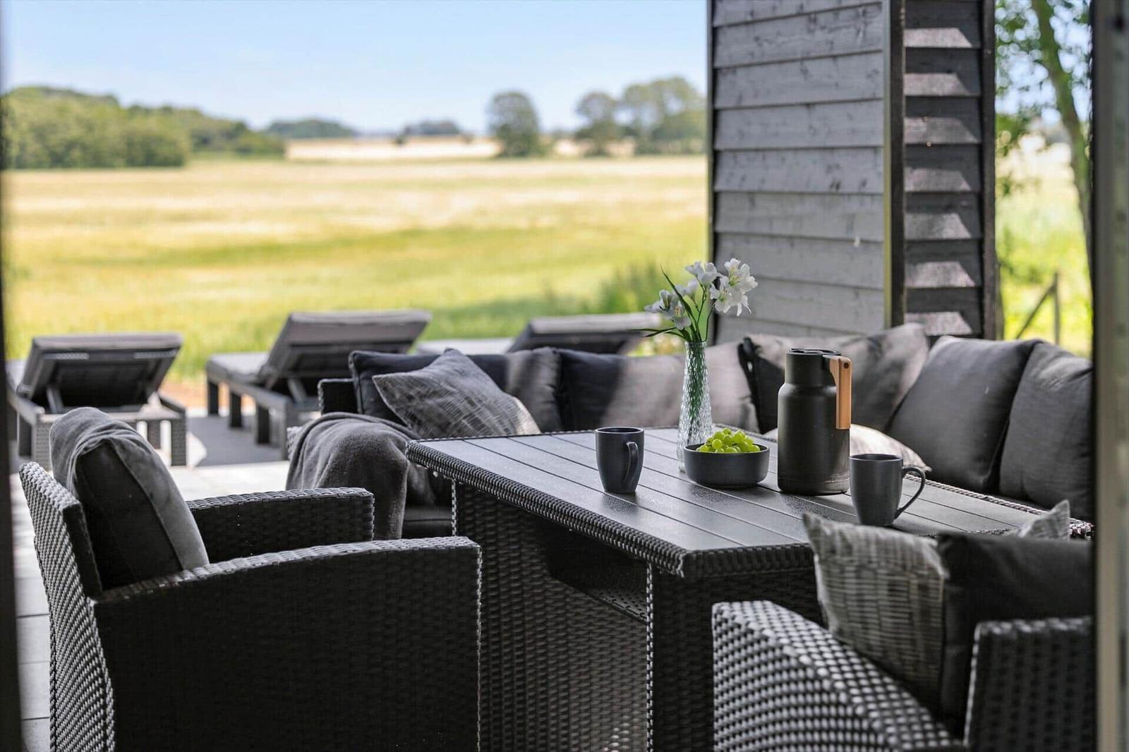 Terrasse mit Sitzgruppe, Tisch und Blick auf Feld