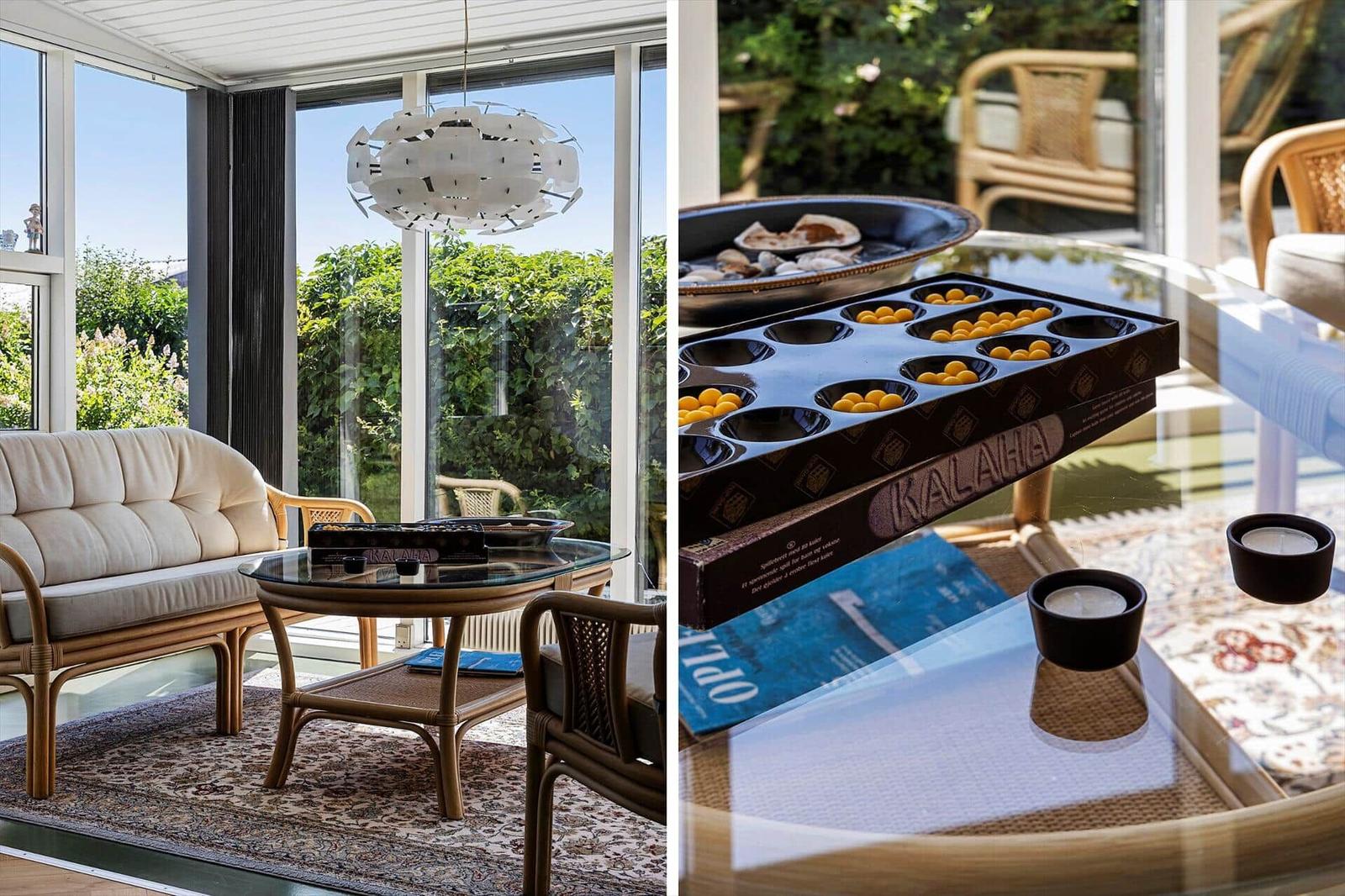 Rattan furniture and glass table indoors. On the table is a game with stones.