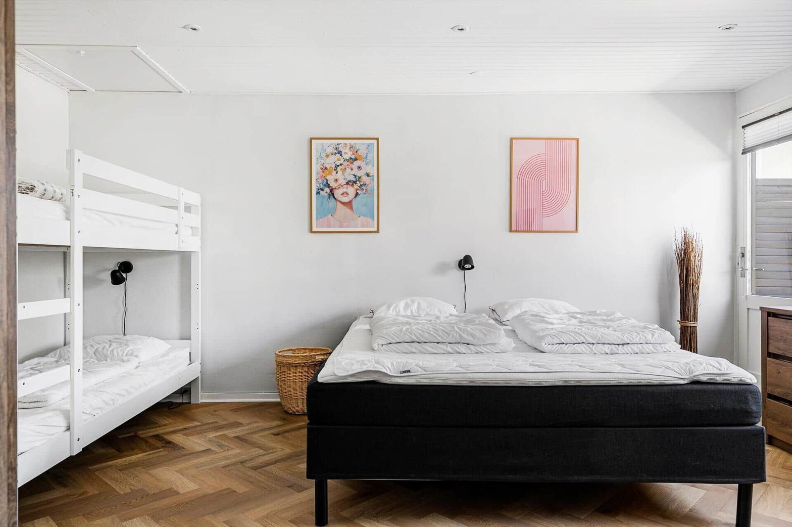 Bedroom with double bed, bunk bed, and wall art.