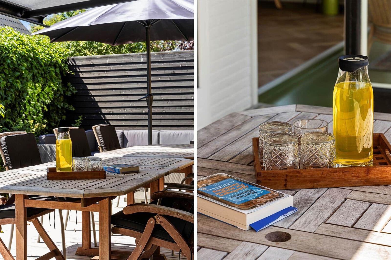 Terrace with table, chairs, umbrella, and drinks.