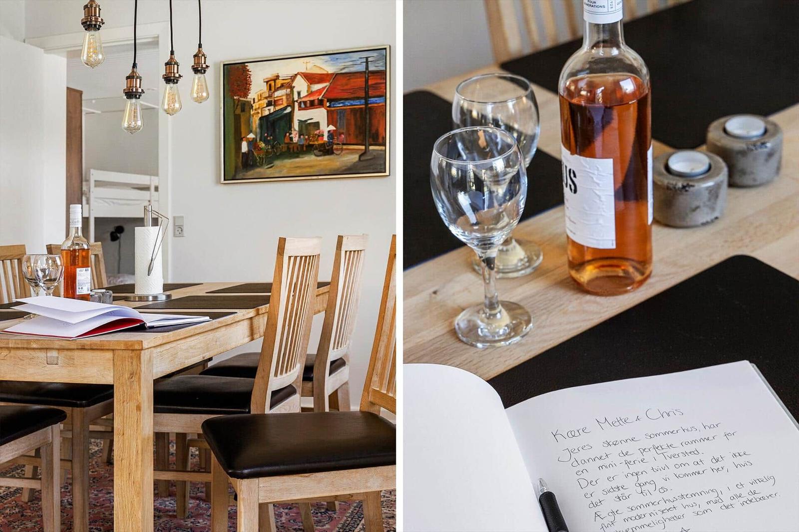 Dining room with wooden table, chairs, and wine. Notebook and bottle on table.