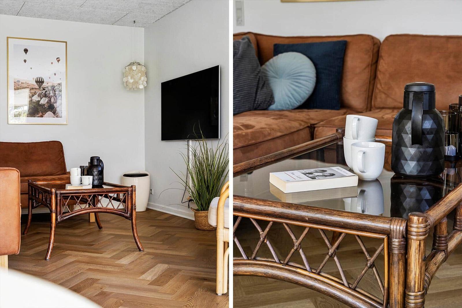 Living room with brown sofa, glass table, and wall-mounted TV.