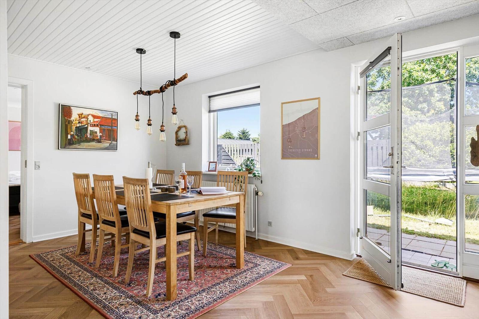 Dining room with wooden table, chairs, and window to outdoor terrace.