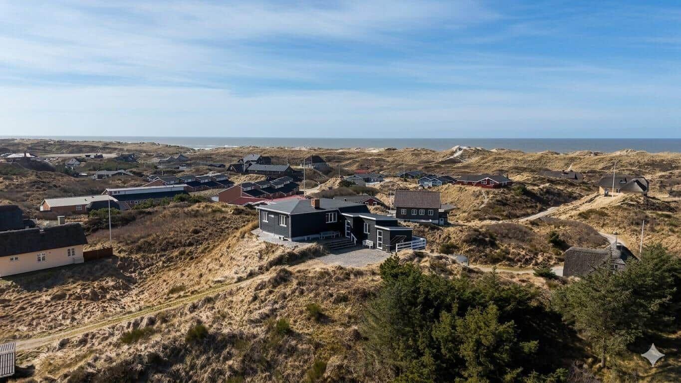 Haus auf Dünen mit Meerblick und Blick auf die Küstenlandschaft.