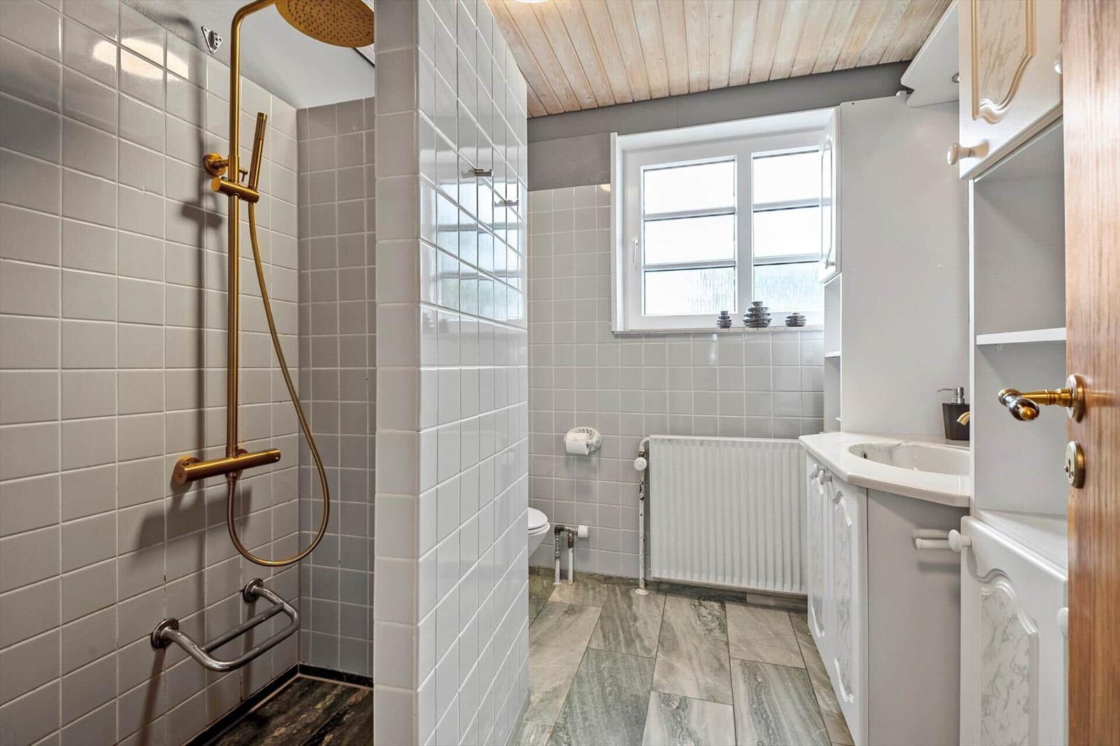 Badezimmer mit Dusche, Waschbecken und Fenster