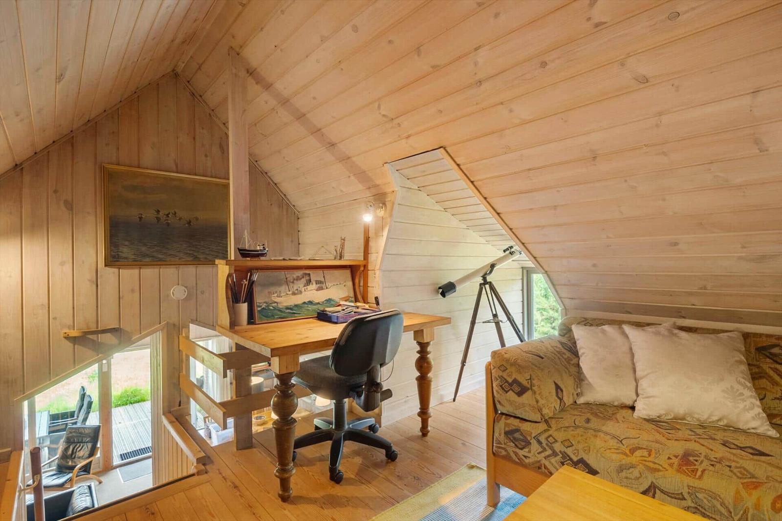 Ein Raum mit Schreibtisch, Sofa und Teleskop. Holzwände und -decke. Fenster zur Aussicht.