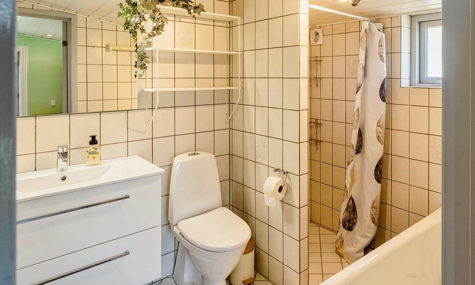 Bathroom with toilet, sink, and shower with curtain.