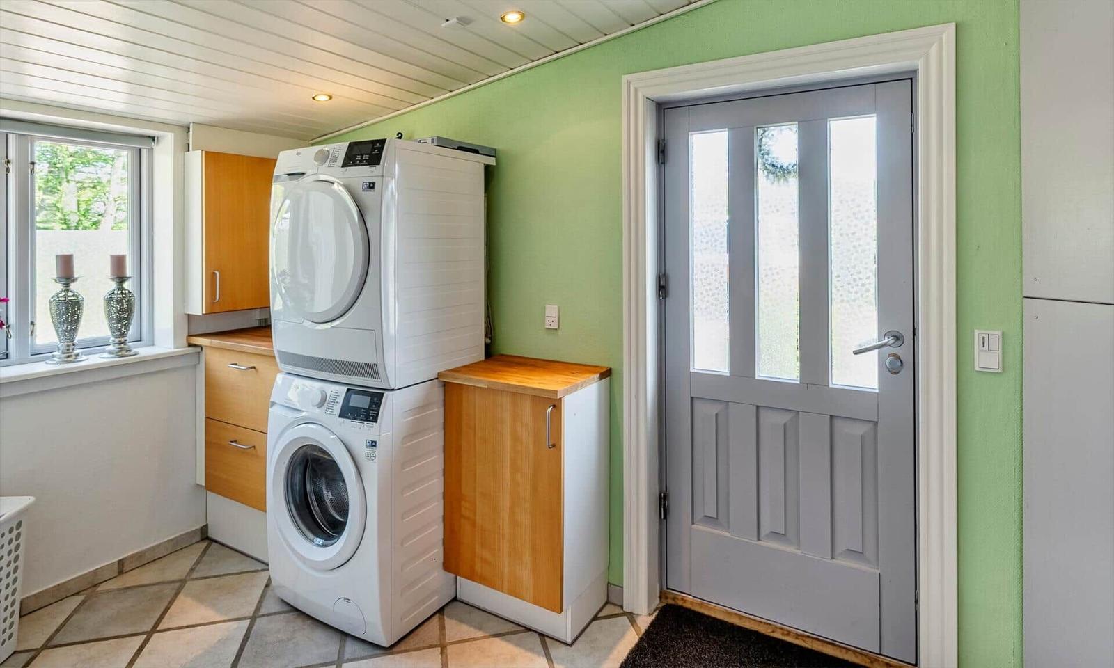 Laundry room with dryer and washing machine, door and window