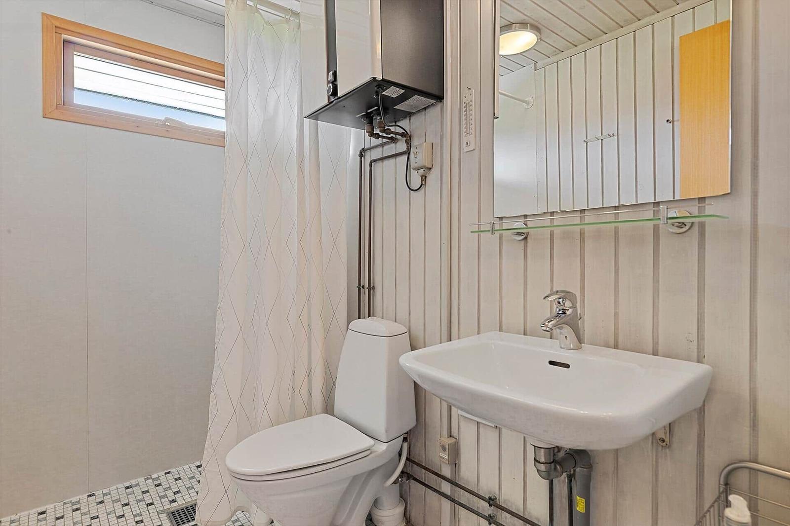 Bathroom with toilet, sink, and shower with curtain.