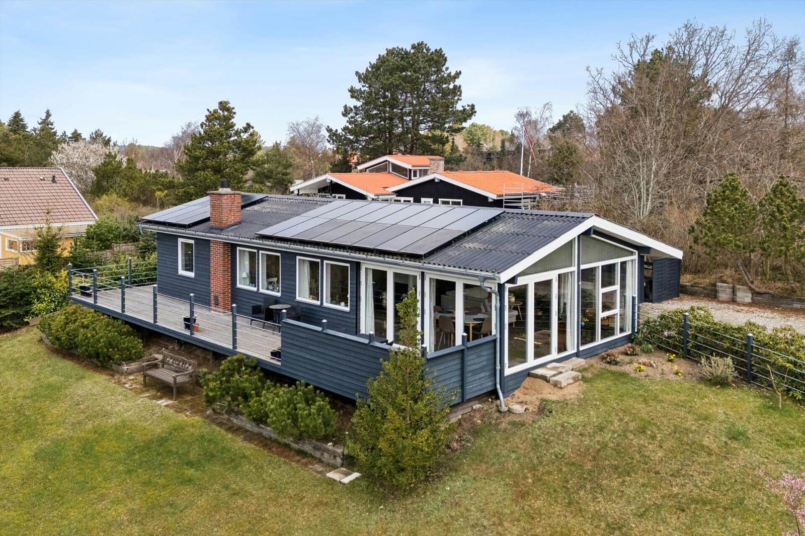 Ein modernes Haus mit Solaranlage und großem Balkon im Grünen.