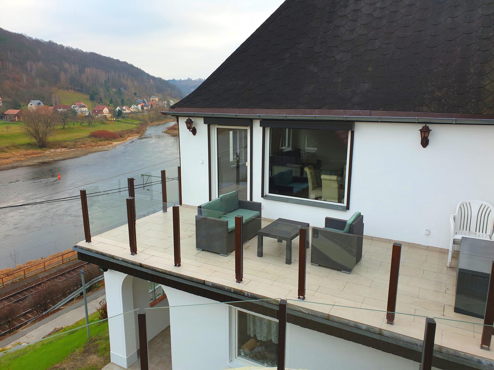 Terrasse mit Sitzgruppe und Blick auf Fluss und Hügel