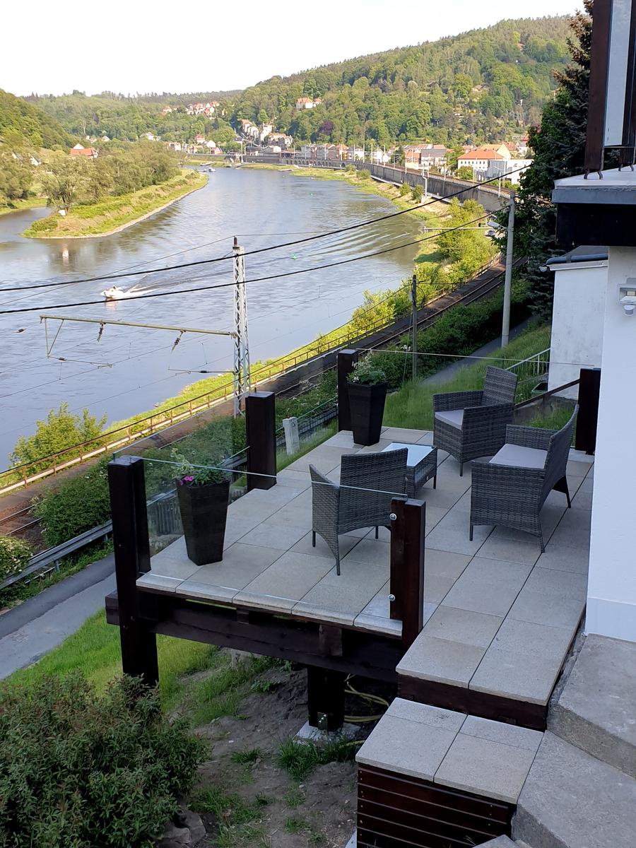 Terrasse mit Sitzgruppe und Blick auf Fluss und Hügel