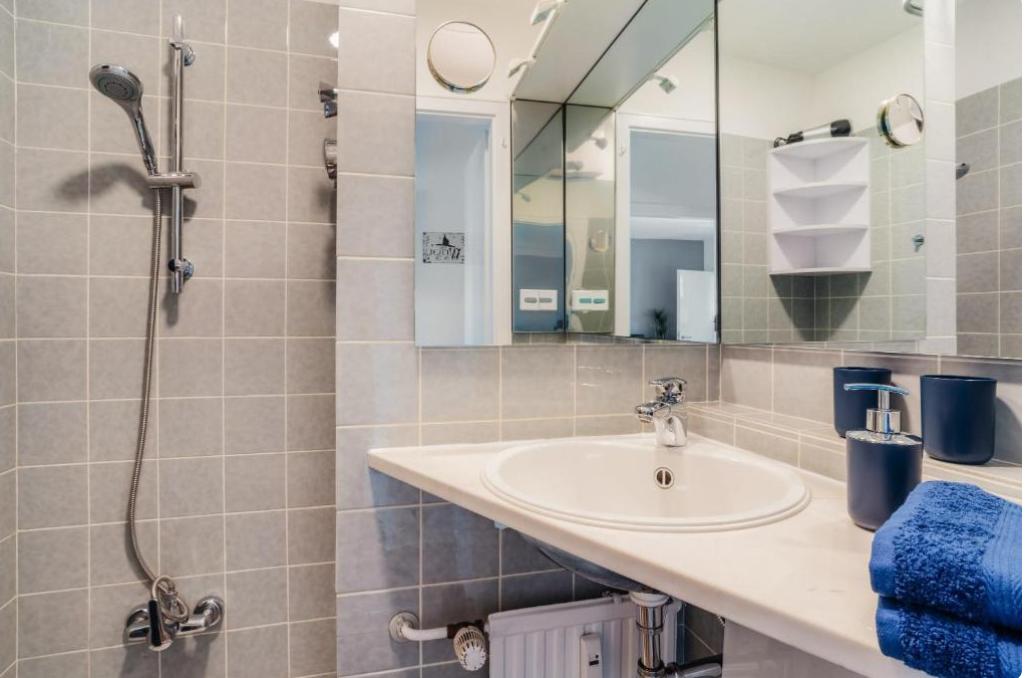 Badezimmer mit Dusche, Waschbecken und Spiegel