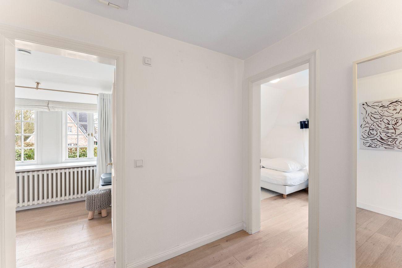 Durchgang mit Blick in Schlafzimmer und Wohnbereich mit Fenster und Heizkörper.